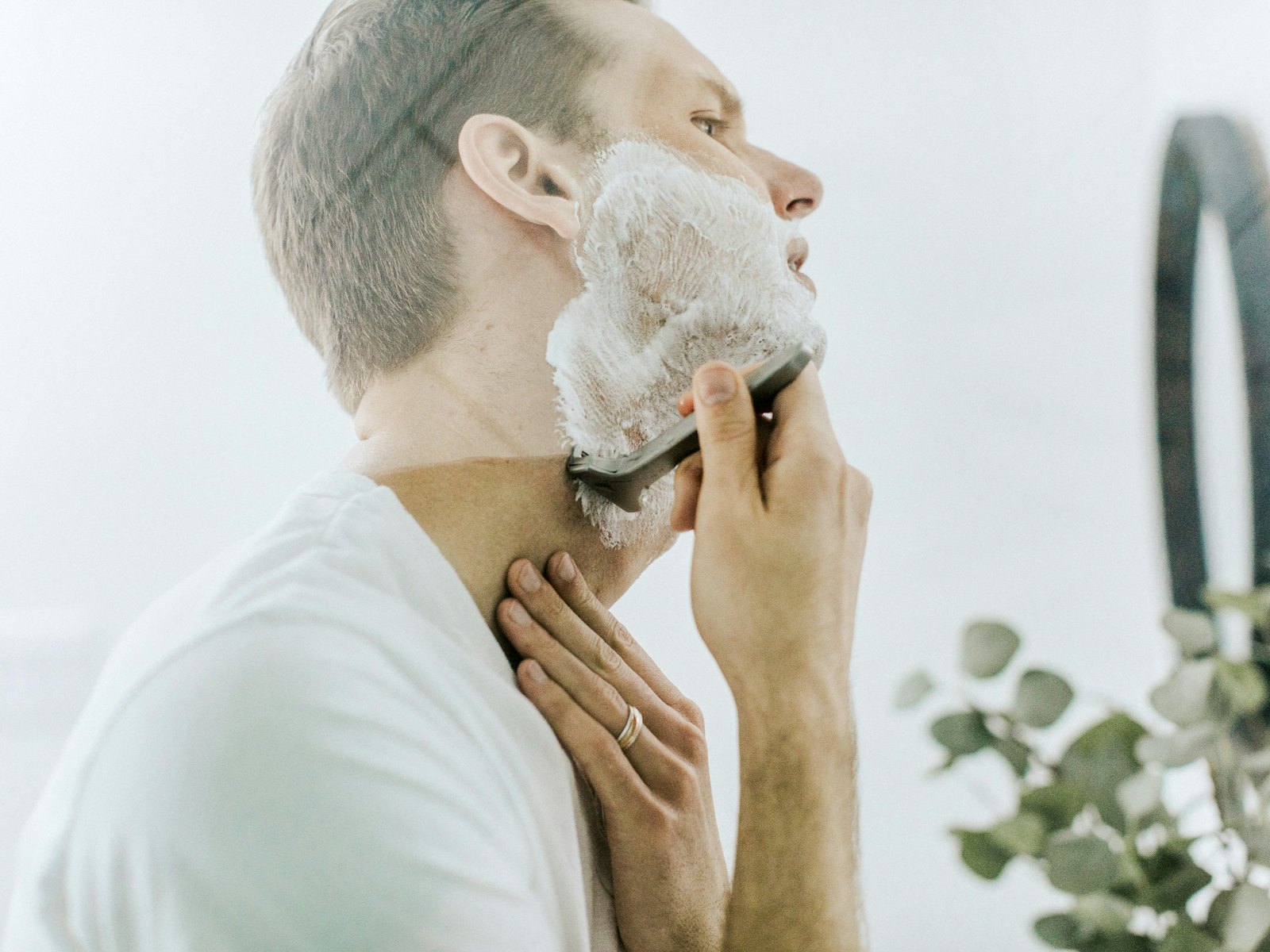 Hombre afeitándose la barba frente al espejo